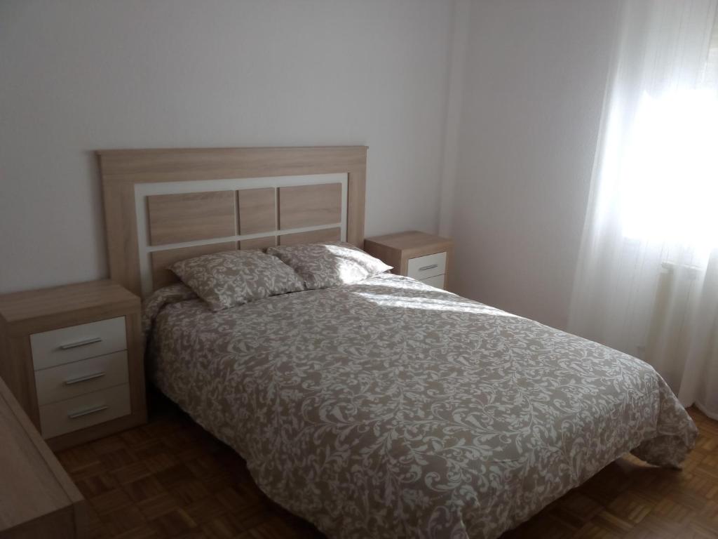 a bedroom with a bed and two night stands and a window at Calle Lardero Apartamento in Logroño