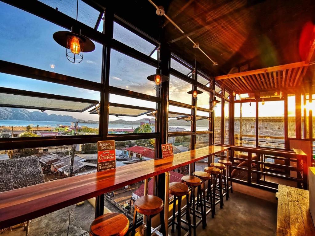 un bar con taburetes y vistas al océano en Michel'inn Coron en Corón