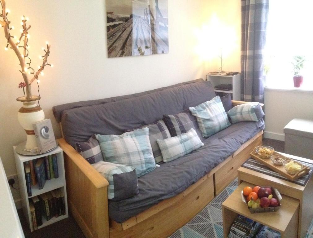 a couch in a living room with a table at LossieBeach Apartment in Lossiemouth