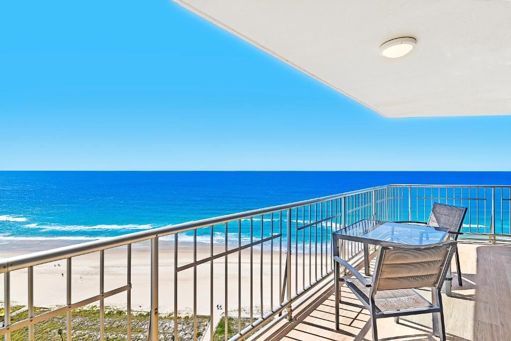 a balcony with a table and chairs and the beach at Talisman Apartments in Gold Coast