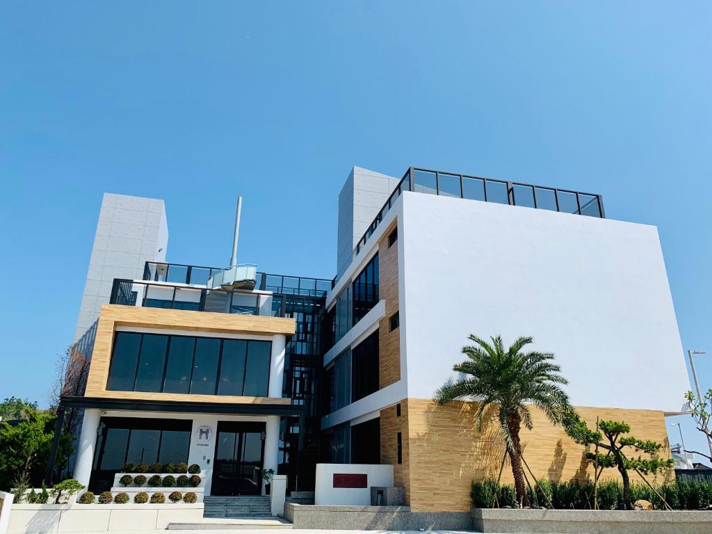 un edificio con una palmera delante de él en Hygge Homestay, en Huxi