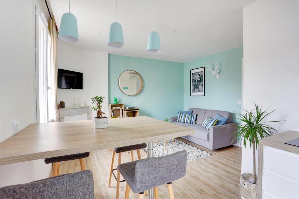 cocina y sala de estar con mesa y sillas en L'Amandine ,45 m2 terrasse et garage centre ville, en Saint-Raphaël