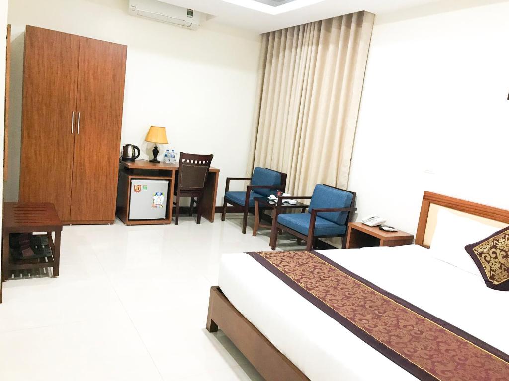 ein Hotelzimmer mit einem Bett, einem Tisch und Stühlen in der Unterkunft Kim Thai Hotel in Thái Nguyên