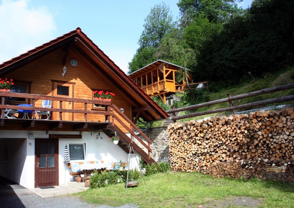 Cette maison en bois dispose d'un balcon sur le côté. dans l'établissement Ferienwohnungen mit Wellnessoase im Luftkurort Altenbrak, à Altenbrak