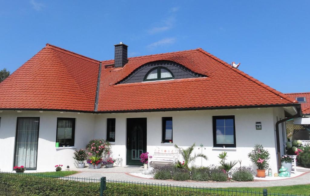 una casa blanca con techo naranja en Ferienwohnung Claudia, en Zinnowitz