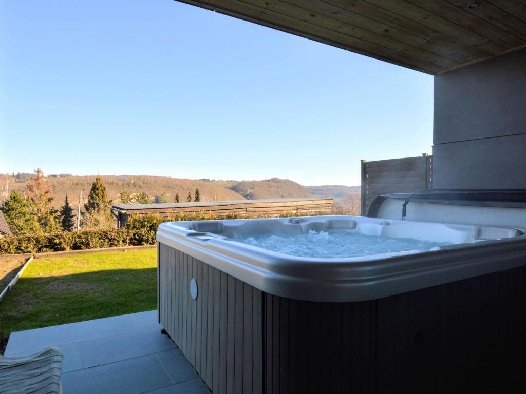 uma banheira de hidromassagem numa varanda com vista em Luxurious Cottage in Aywaille with Sauna and bubble bath em Aywaille