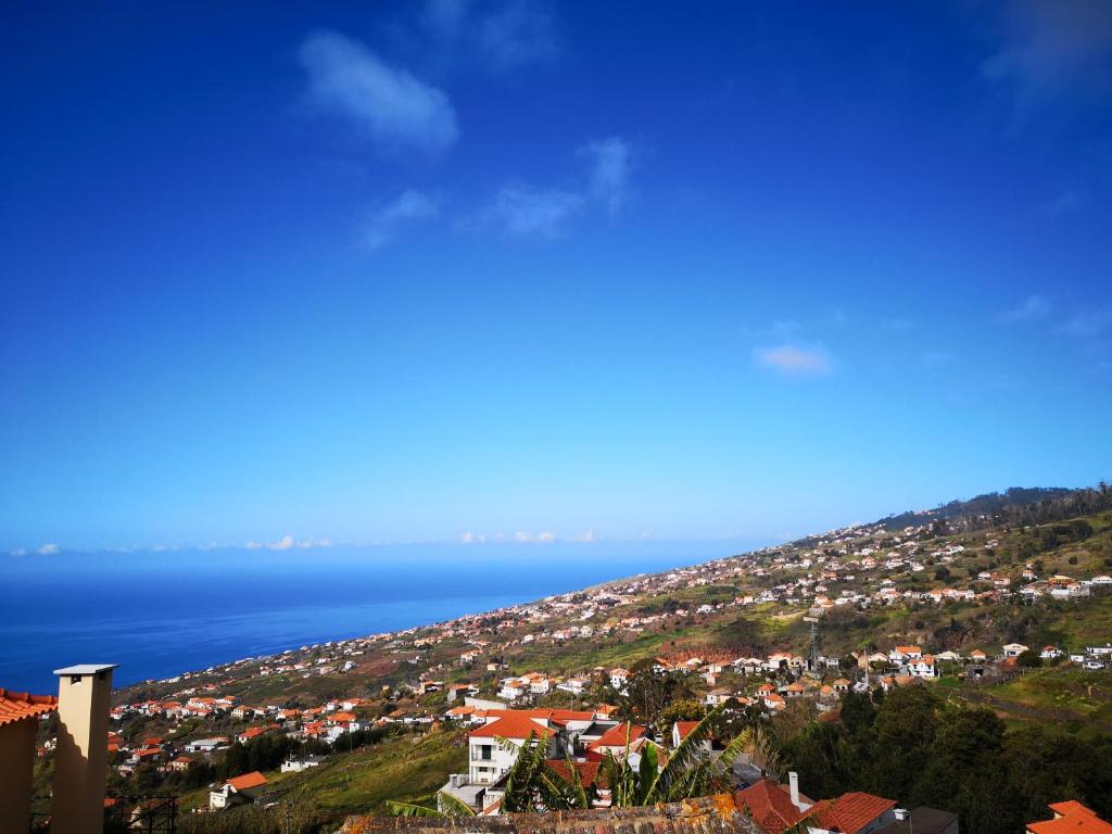 a town on a hill with the ocean in the background at Madeira Inn Casa da Paz in Calheta