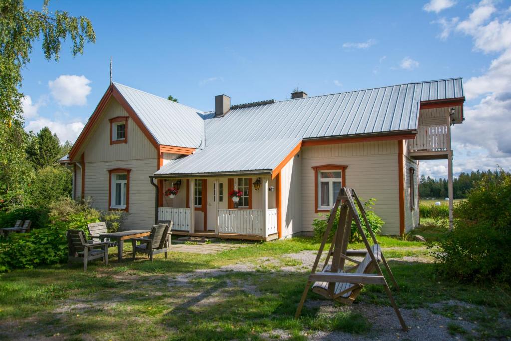 una casa con un porche y una mesa frente a ella en Villa Rentola, en Pääjärvi