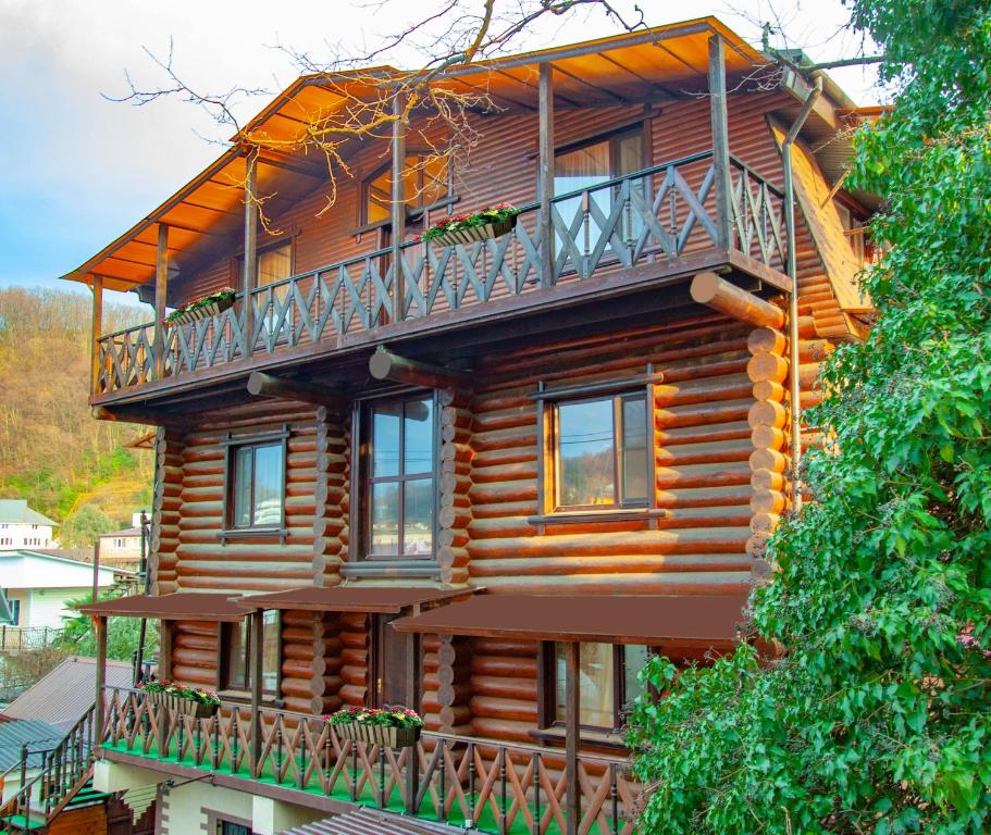 a wooden house with a balcony on the side of it at ШарЛООтка in Loo