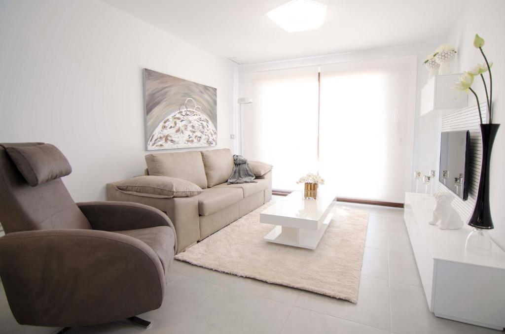 a living room with a couch and a chair at Mar de Pulpí Costa de Almeria by Mar Holidays in San Juan de los Terreros