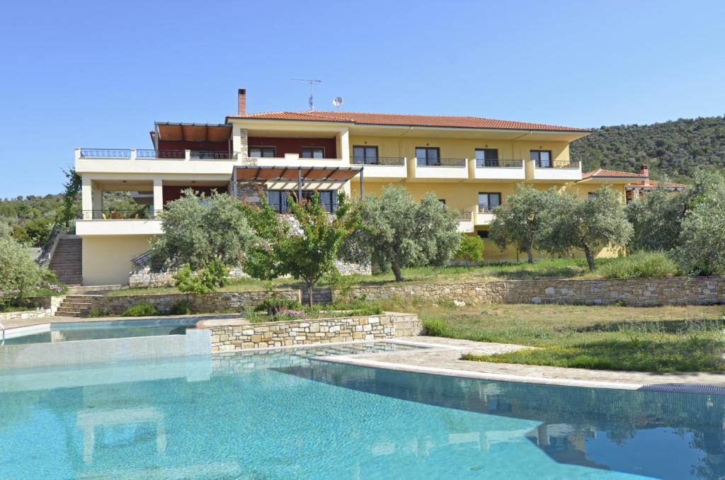 uma villa com piscina em frente a uma casa em Moonbeam Hotel em Pefkari