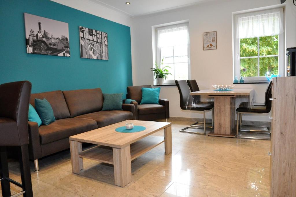 ein Wohnzimmer mit einem Sofa und einem Tisch in der Unterkunft Apartmenthaus am Zimmerplatz in Hofheim am Taunus