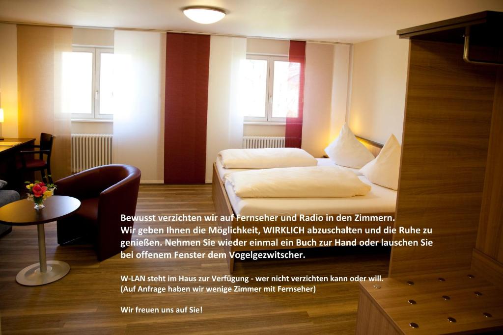 une chambre d'hôtel avec un lit et un canapé dans l'établissement Tagungshaus Regina Pacis, à Leutkirch im Allgäu