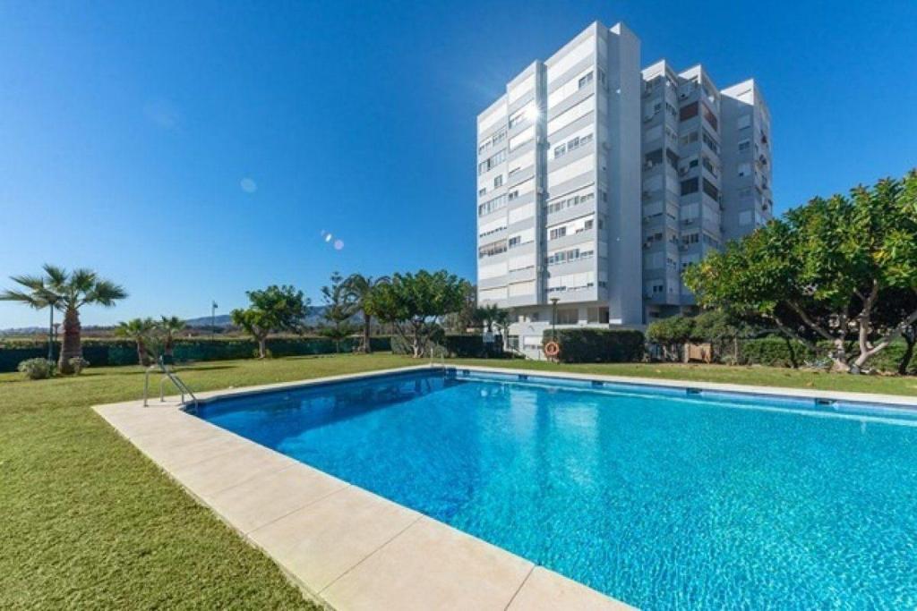 een groot zwembad voor een gebouw bij Sunny Beach in Málaga