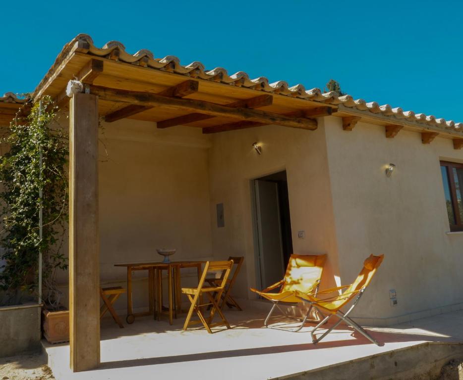 un patio con sedie e tavolo di fronte a una casa di La Casa del Miele di Borgo Carbone a Locri