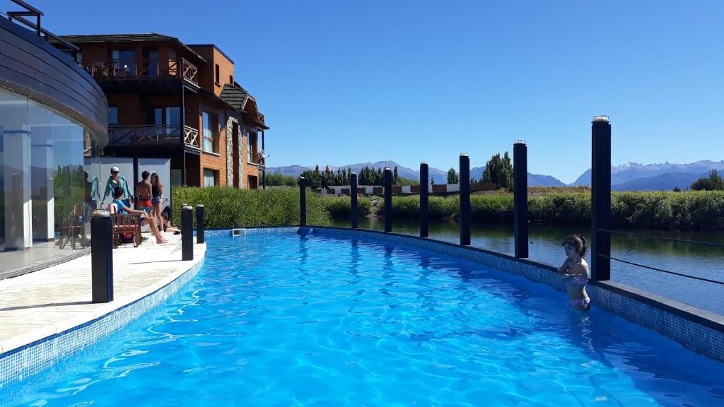 a little girl standing in the water in a swimming pool at Encanto sobre el Nahuel in Dina Huapi