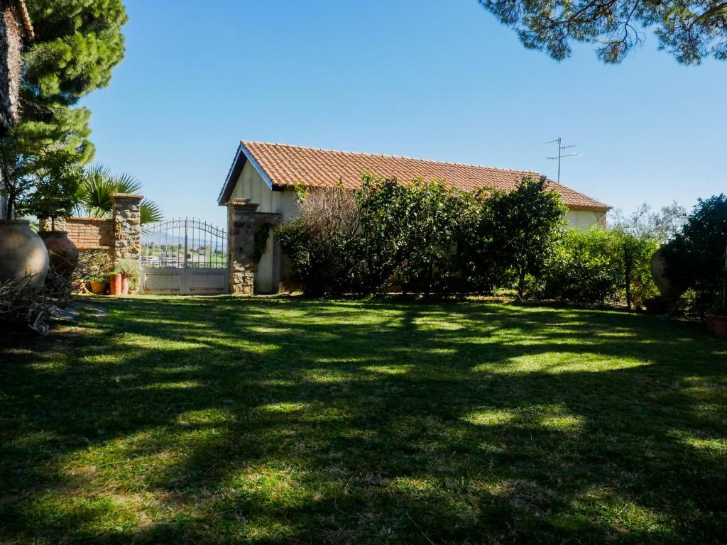 ein Haus mit einem großen Garten mit großem Rasen in der Unterkunft La Casetta di Borgo Carbone in Locri