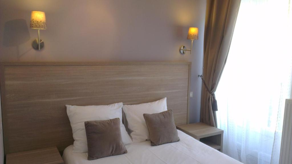 um quarto com uma cama branca e 2 almofadas em Luxelthe em Paris