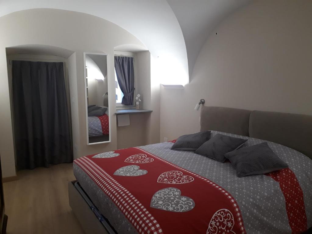 a bedroom with a bed with a red and white blanket at Aosta Romana case vacanza in Aosta