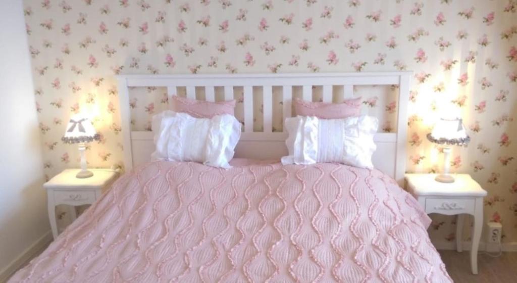 a bedroom with a pink bed with two tables at Romantic Style Apartment Berlin Alexanderplatz in Berlin