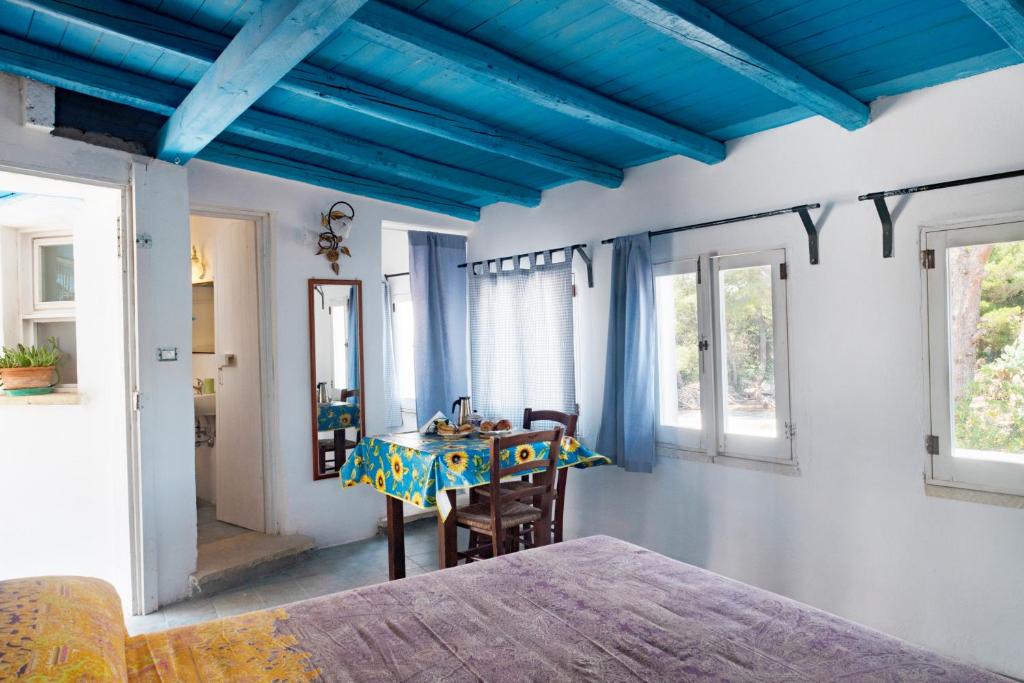 una camera da letto con soffitti blu e tavolo e sedie di Casa Vacanze Capurre "Trulli e Pajare a due passi dal Pizzo" a Gallipoli