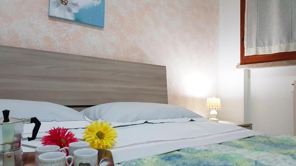 een slaapkamer met een bed met bloemen op een tafel bij Casa Excalibur in Pisa