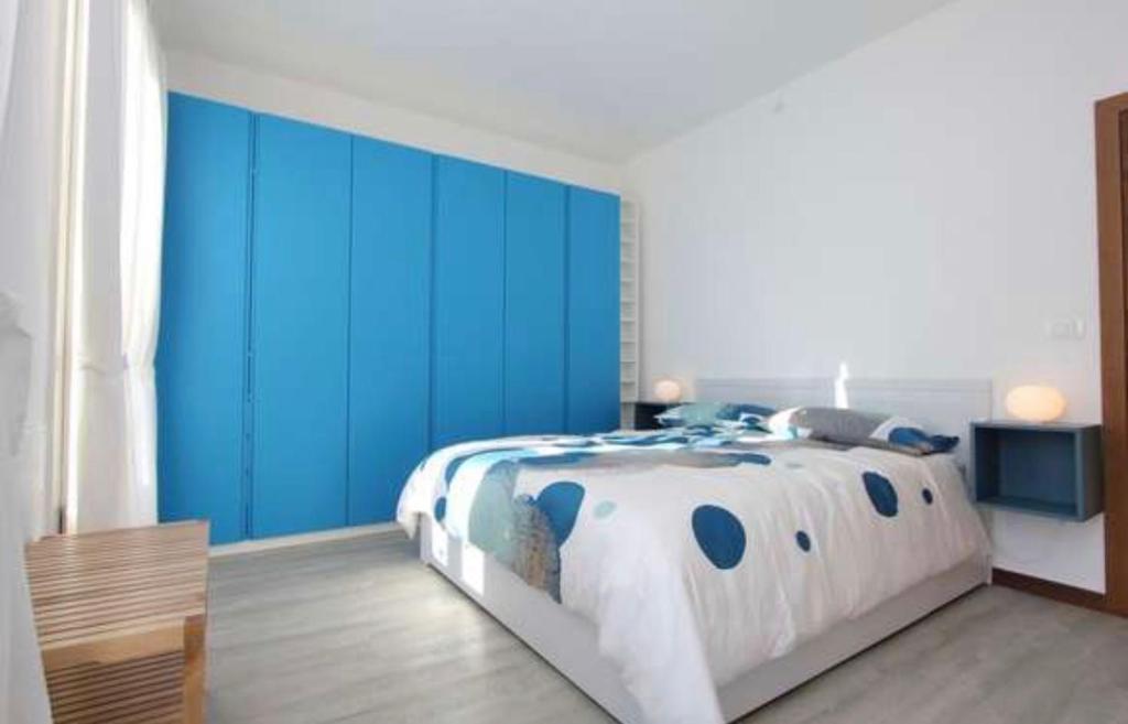 a bedroom with a large bed with blue walls at Al CINEMA ITALIA in Venice