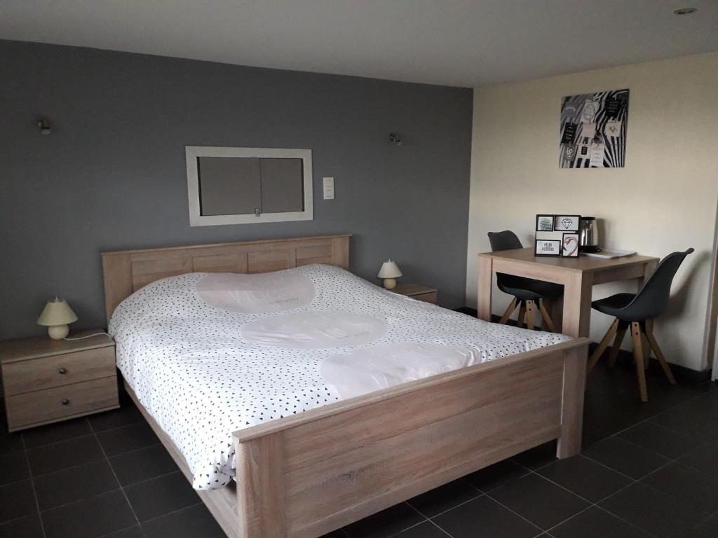 - une chambre avec un lit, une table et un bureau dans l'établissement A La Reid Paisible, à Theux