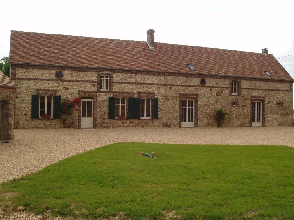 a large brick building with a grass yard in front of it at GITE DE LA BRETILLIERE in Les Menus