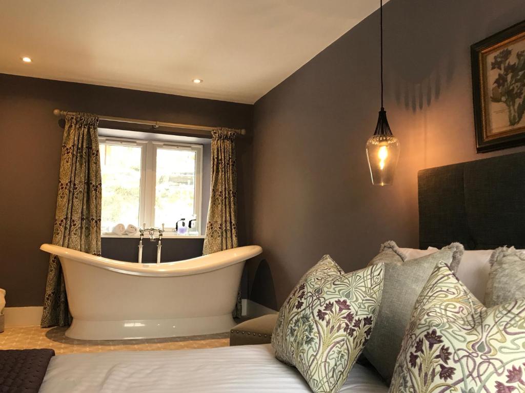 a bedroom with a bath tub and a bed at The Cottage in Dunblane