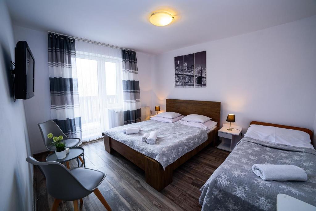 ein Schlafzimmer mit 2 Betten und einem Stuhl darin in der Unterkunft Królowa Śniegu in Karpacz