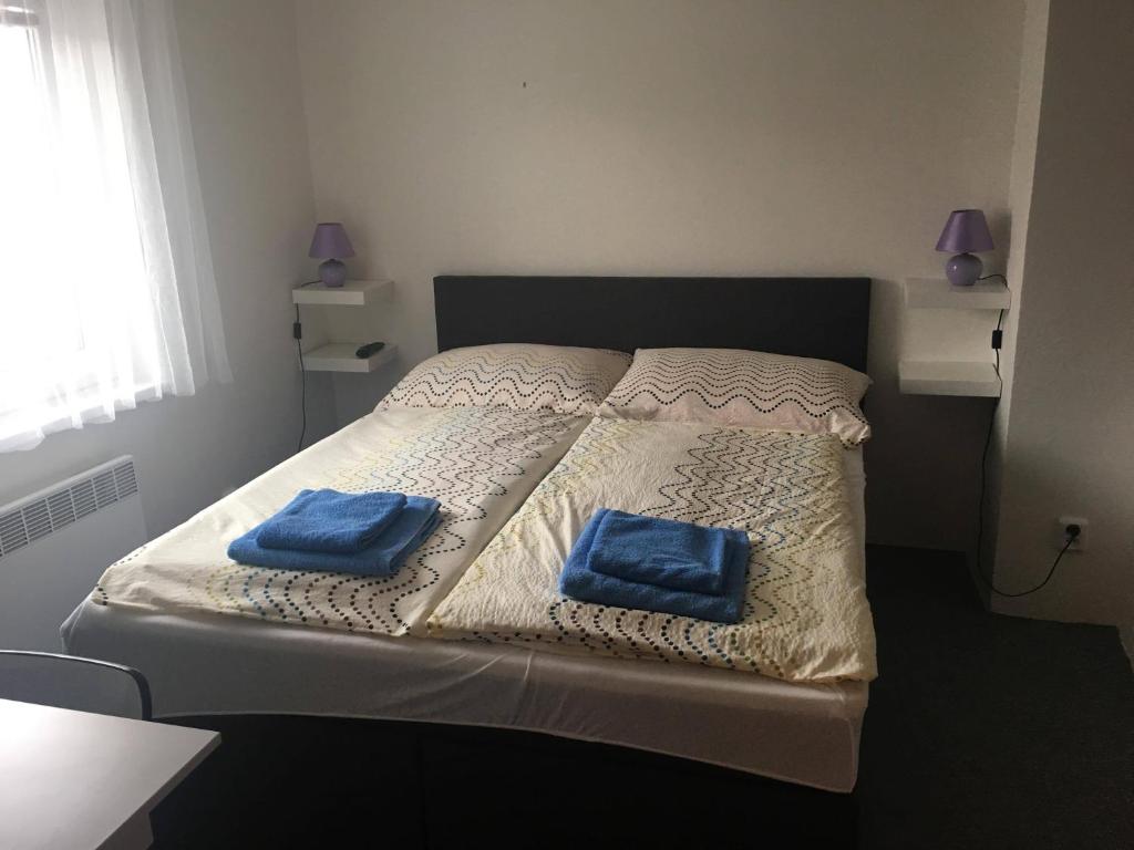 ein Bett mit zwei blauen Kissen darüber in der Unterkunft Rodinný penzion in Mikulov