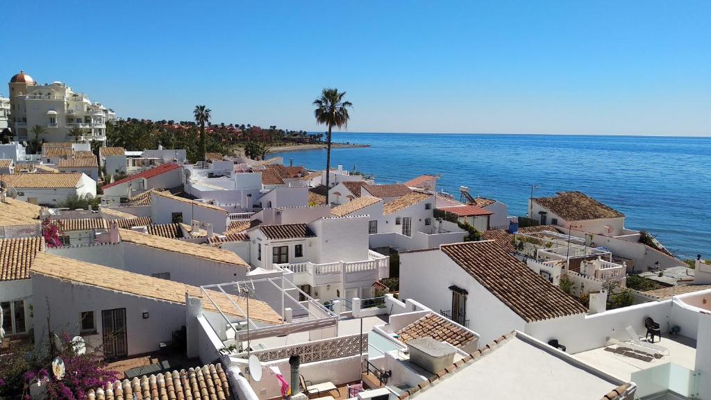 a view of a town with white houses and the ocean at Casa Cachita-En 1ª línea de playa in Estepona