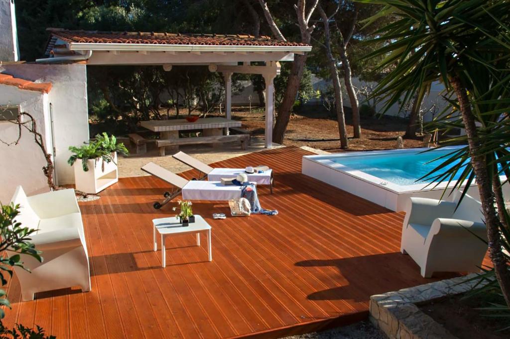 un patio con tavolo, sedie e piscina. di Villa Conca D'oro a Gallipoli