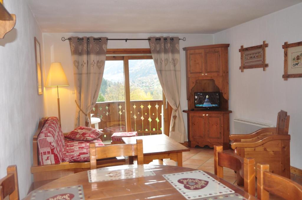 un salon avec une table et un canapé dans l'établissement Résidence MGM 3* 199 Chemin du Verney du Fouilly les hauts de chavants, aux Houches
