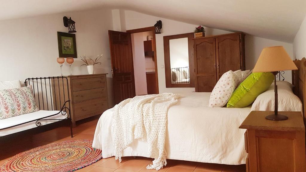 um quarto com uma cama com um candeeiro e uma cómoda em APARTAMENTO 1 CASA RURAL EL SAUCE. A 2,5 KM DE CUENCA CAPITAL em Nohales
