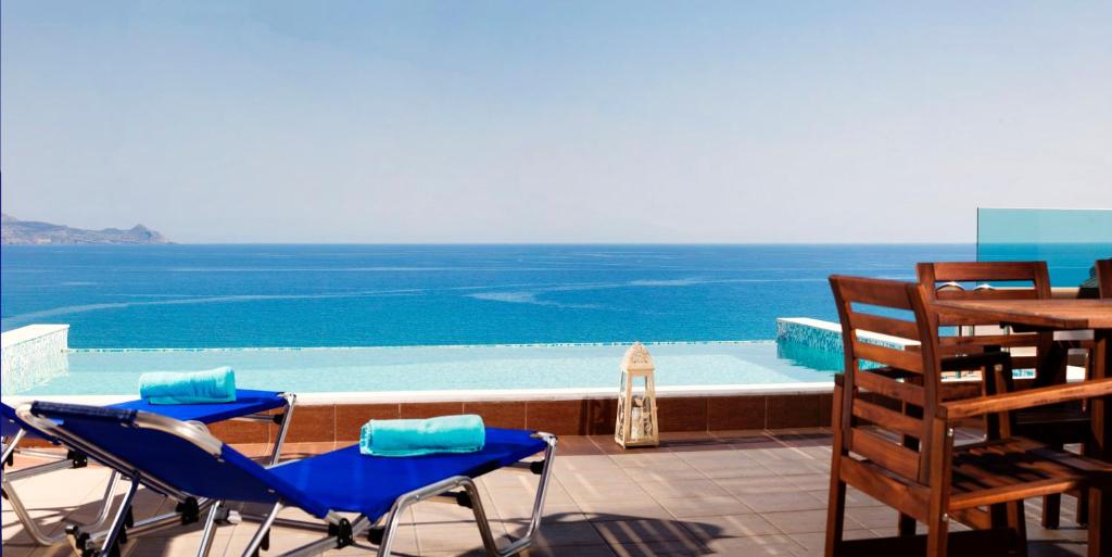 a patio with chairs and a table and the ocean at Luxury Villa Panorama in vlicha