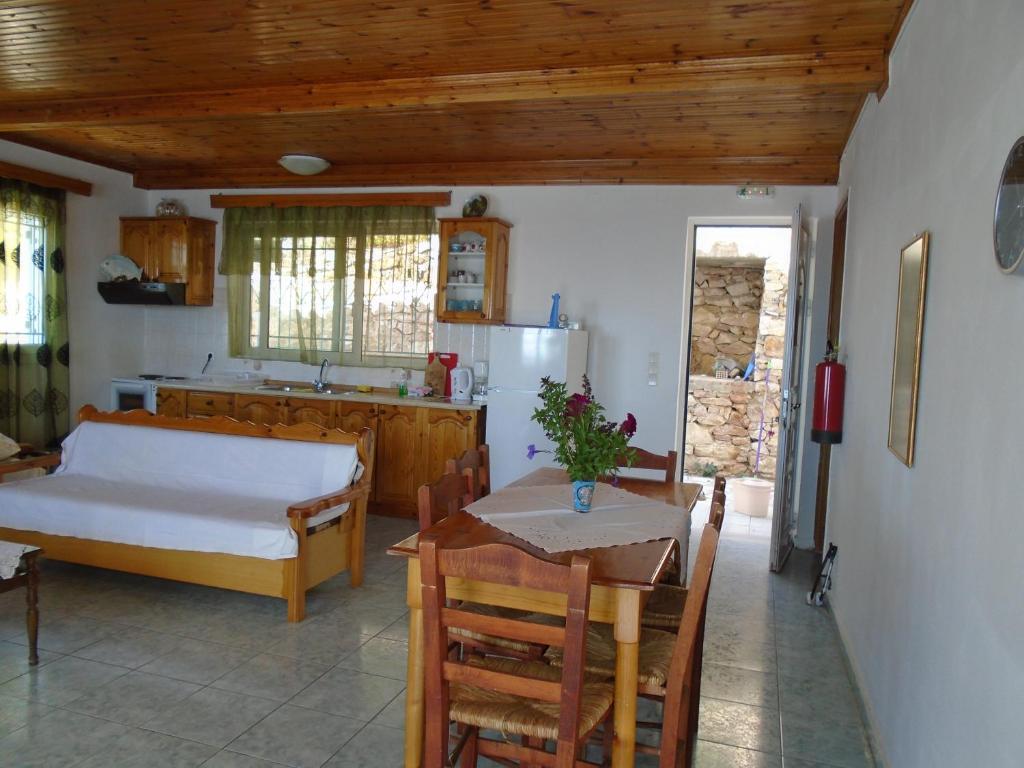 a kitchen with a table and a bed and a table and chairs at Giota & Antonia Apartments in Koroni