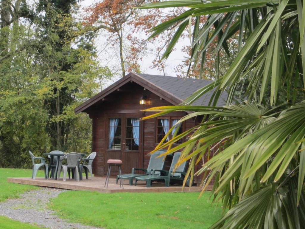 a cabin with tables and chairs in front of it at CHALET GOYAVE in Épaignes