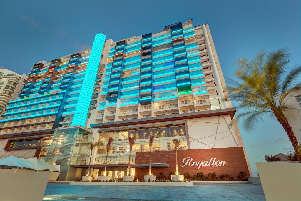 un gran edificio con una palmera delante en Royalton CHIC Cancun, An Autograph Collection All-Inclusive Resort - Adults Only, en Cancún
