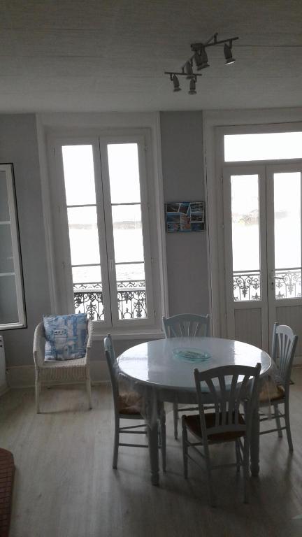 une salle à manger avec une table, des chaises et des fenêtres dans l'établissement 10 Quai François 1er, au Tréport