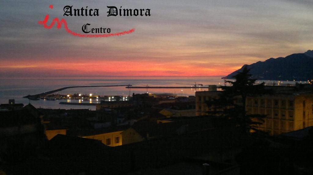 - une vue sur une ville avec un coucher de soleil en arrière-plan dans l'établissement Antica Dimora in Centro, à Salerne