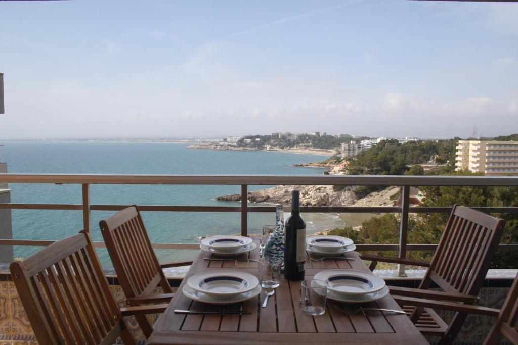 a wooden table with a bottle of wine on a balcony at Synergie SI09 - La Jota in Salou