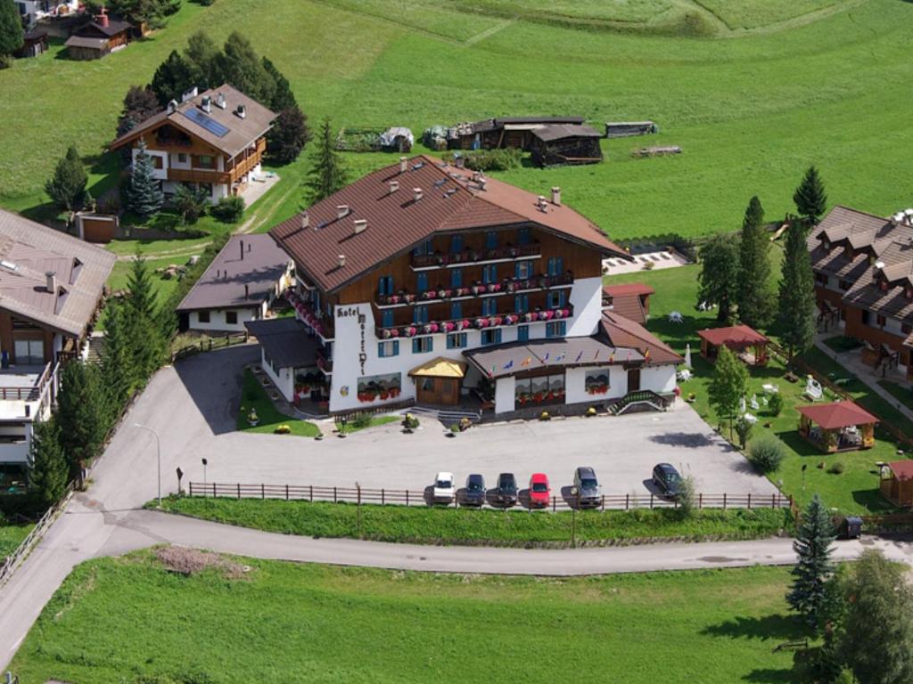 an aerial view of a large building with cars parked outside at Park Hotel Mater Dei in Pozza di Fassa
