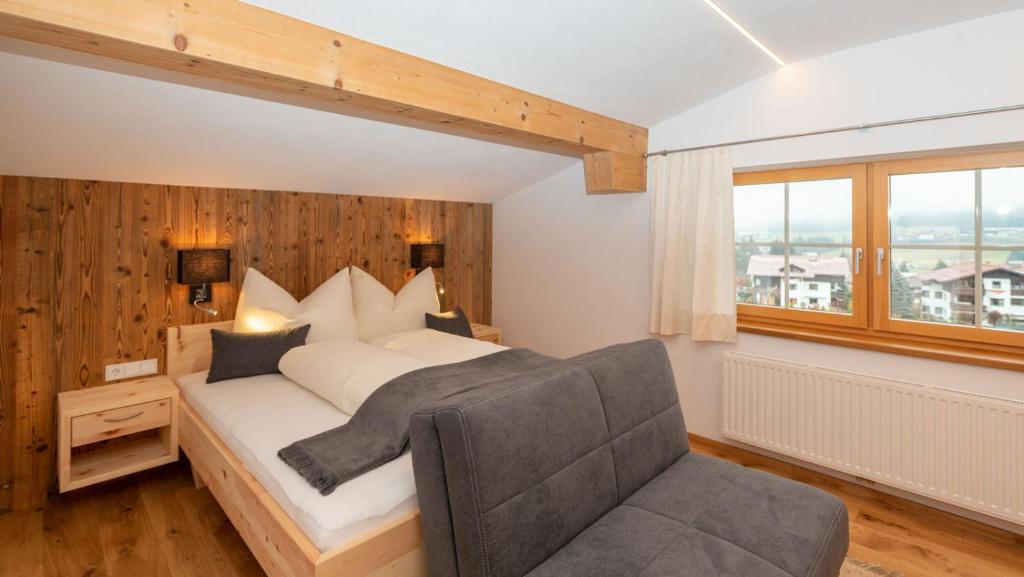 ein Schlafzimmer mit einem Bett, einem Stuhl und einem Fenster in der Unterkunft Haus Horngacher in Fieberbrunn