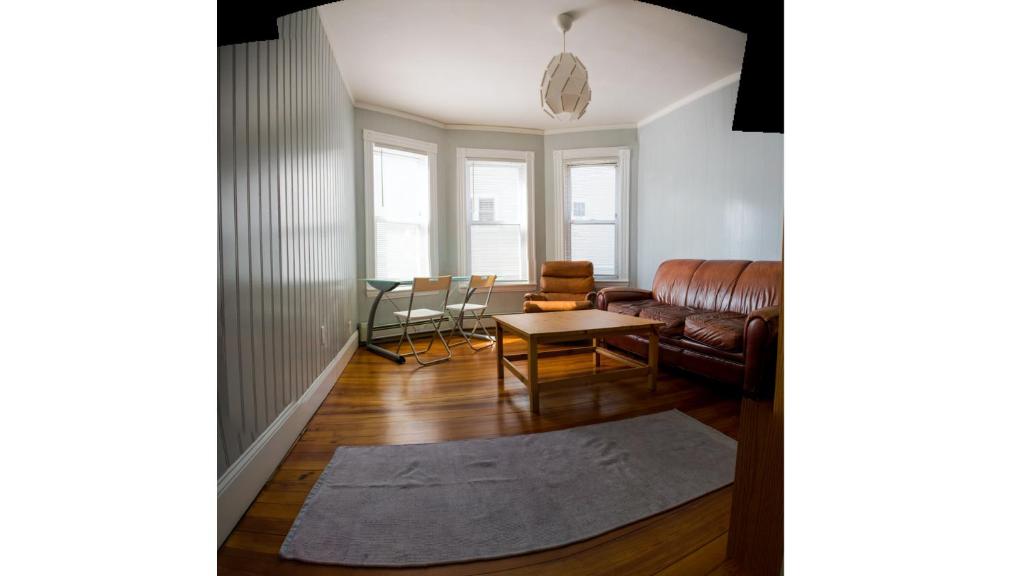 a living room with a couch and a table at Boston Homestel in Boston