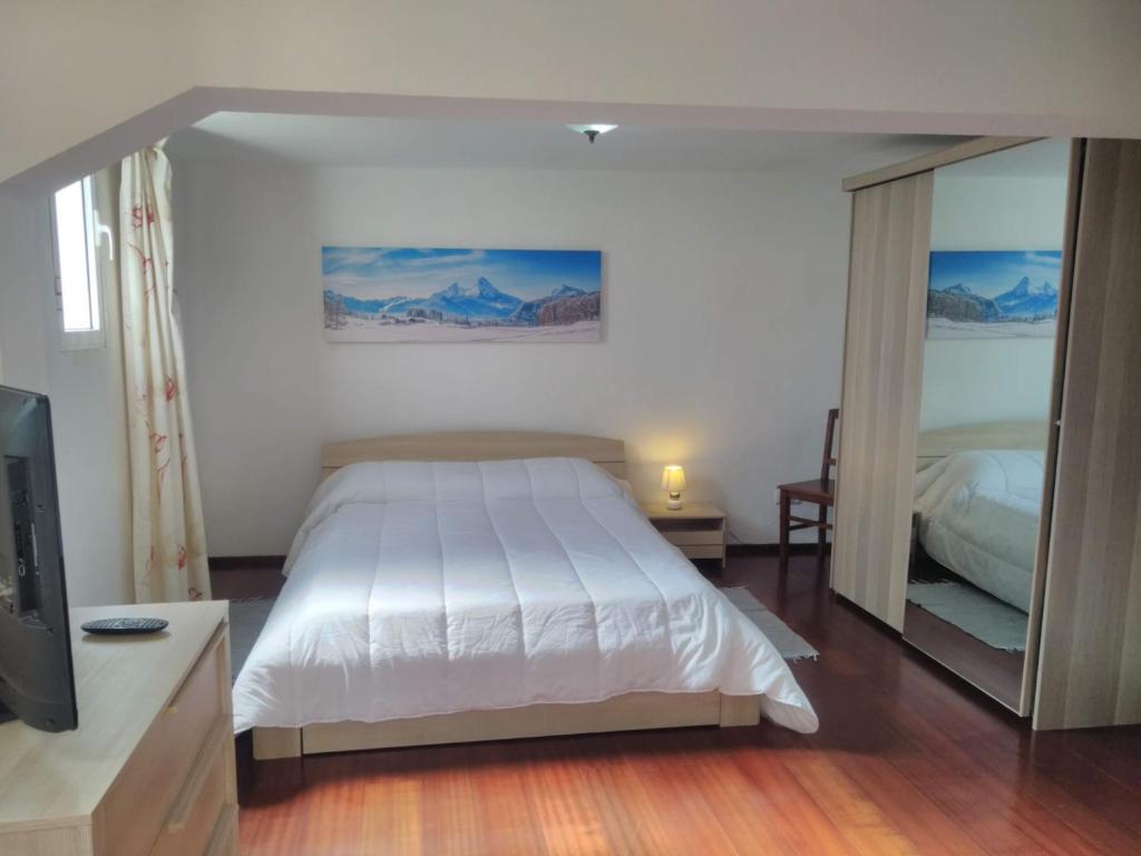 een slaapkamer met een groot bed en een spiegel bij Casa do Figueirinha in Campanário