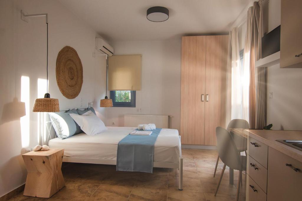 a small bedroom with a bed and a kitchen at Kallisti Studios & Apartments in Skiros