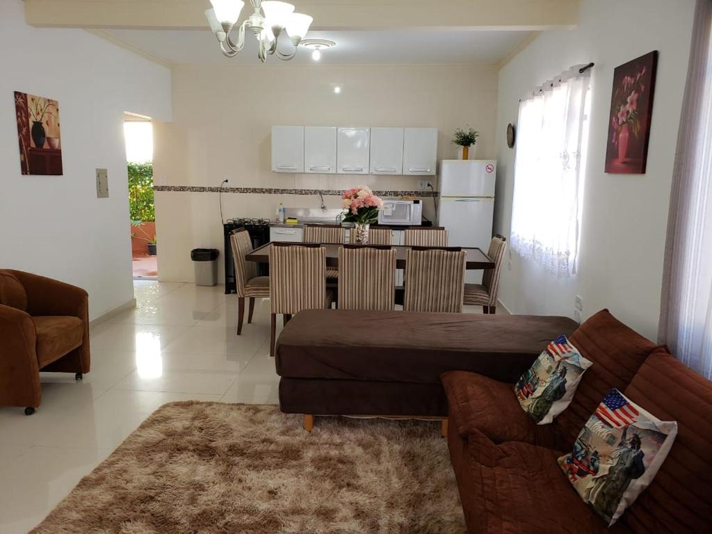 uma sala de estar com um sofá e uma cozinha em Yolanda Family House em Foz do Iguaçu