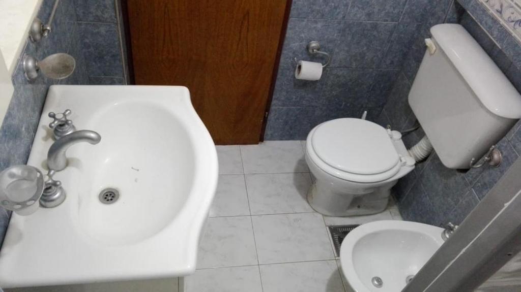 a bathroom with a white toilet and a sink at Roberta in Bahía Blanca